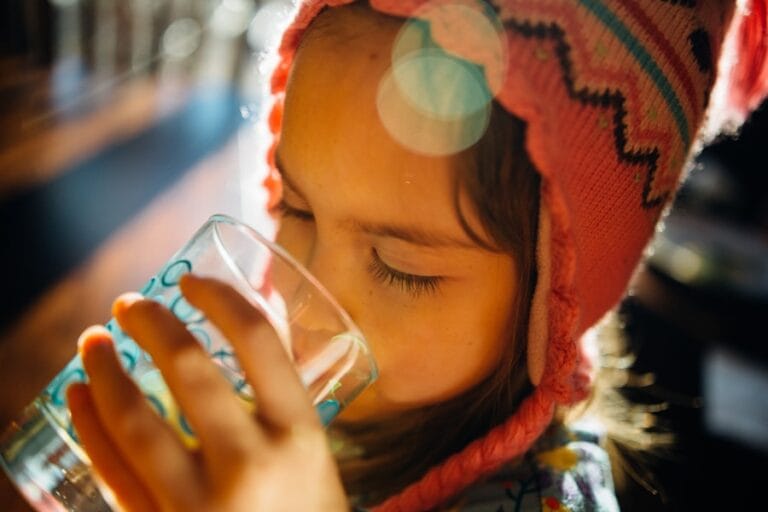 Niña bebiendo agua mineralizada limpia en casa - Boom H2O